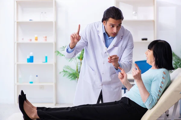 Vecchia visitando giovane medico dentista — Foto Stock