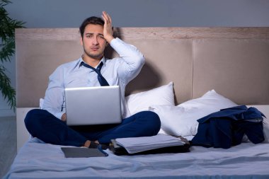 Yorgun işadamı gece fazla mesai yapıyor.