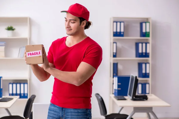 Young male courier delivering postbox to the office — Stock Photo, Image