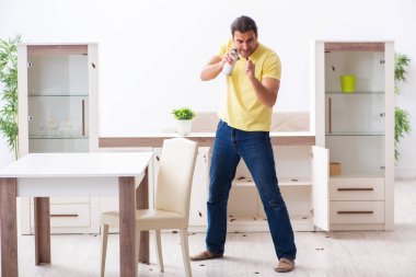 Genç adam ve evde bir sürü hamamböceği var.