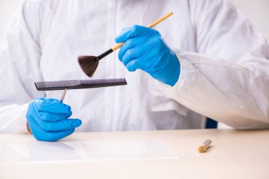 Erkek kriminolog kanıt için laboratuarda çalışıyor.