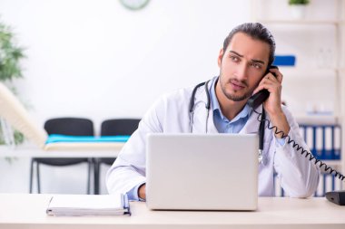 Klinikte çalışan yakışıklı genç erkek doktor.
