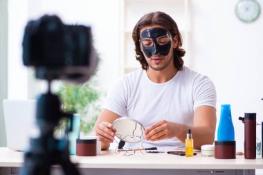 Genç erkek kozmetikçi blogu için video kaydediyor.