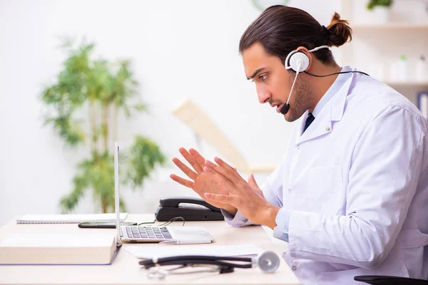 Joven médico escuchando al paciente durante la sesión de telemedicina — Foto de Stock