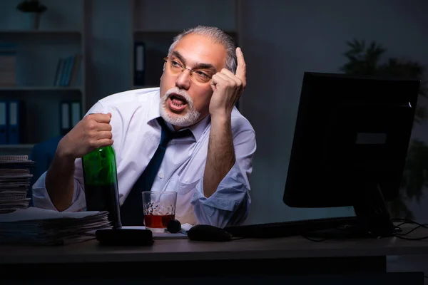 Vecchio dipendente di sesso maschile che lavora fino a tardi in ufficio — Foto Stock