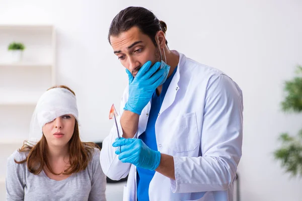 Młoda głowa ranna kobieta odwiedza młodego lekarza — Zdjęcie stockowe