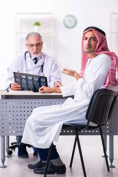 Young male arab visiting experienced male doctor — Stock Fotó