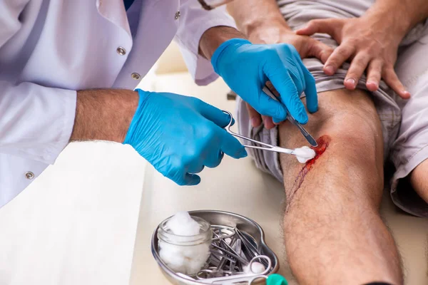 Gamba ferito visitando il vecchio medico nel concetto di pronto soccorso — Foto Stock