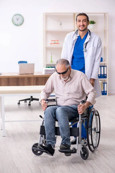 Vecchio cieco visita giovane medico maschio — Foto Stock