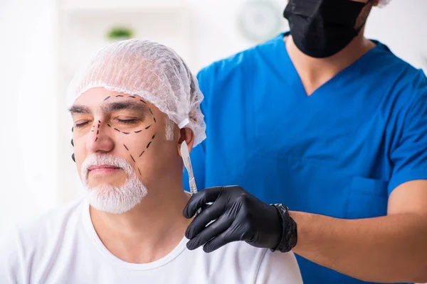 Anciano visitando a doctor masculino para cirugía plástica —  Fotos de Stock