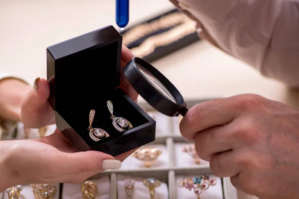 Jonge vrouw op bezoek bij oude mannelijke juwelier — Stockfoto