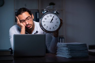 Gece ofiste çalışan genç bir erkek.