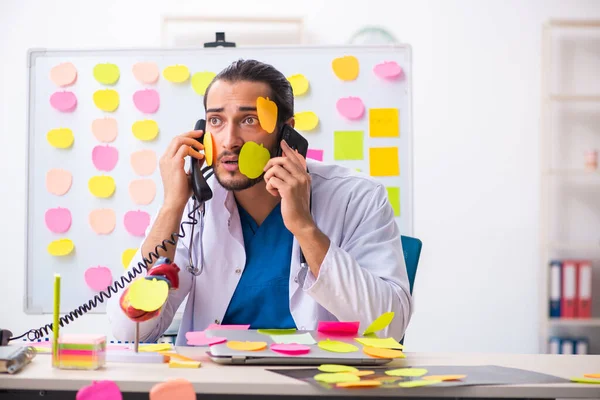 Junge männliche Mediziner in widersprüchlichem Prioritätenkonzept — Stockfoto