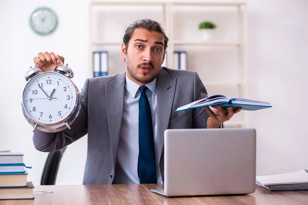 Ung manlig affärsman läser böcker på arbetsplatsen — Stockfoto