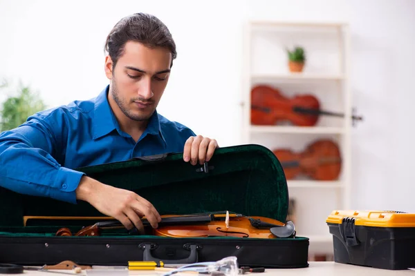 Jeune réparateur masculin réparant violon — Photo