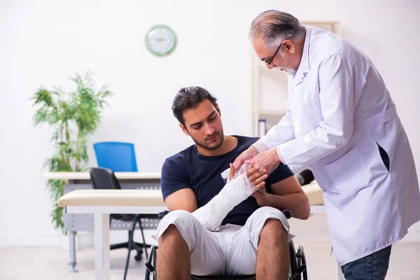 Young injured man visiting experienced male doctor traumatologis — Stock Photo, Image