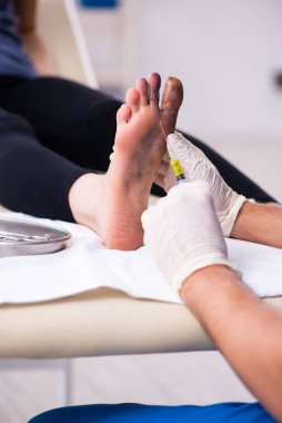 Erkek doktor travmatoloğu ziyaret eden yaralı bir kadın.