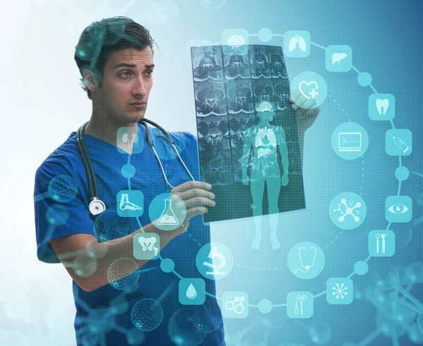 Genç doktor sağlık konseptinde x-ray görüntüsüne bakıyor — Stok fotoğraf
