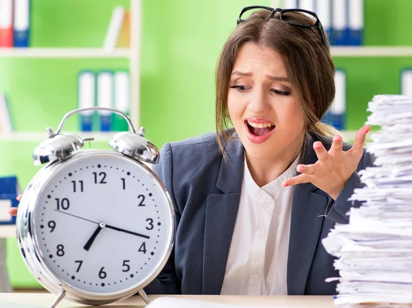 Jonge vrouwelijke werknemer zeer druk met lopende papierwerk in de tijd m — Stockfoto