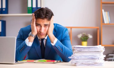 Genç yakışıklı işadamı ofiste çalışıyor.