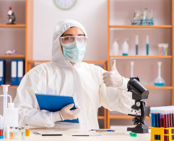 Jonge biochemicus in een beschermend pak in het lab — Stockfoto