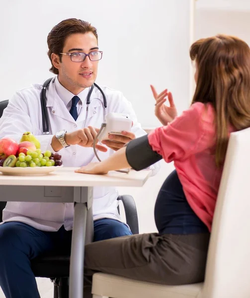 Gravid kvinna besöker läkare diskuterar hälsosam kost — Stockfoto