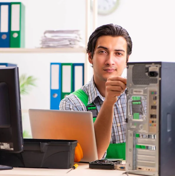 Młody inżynier naprawiający zepsuty komputer w biurze — Zdjęcie stockowe