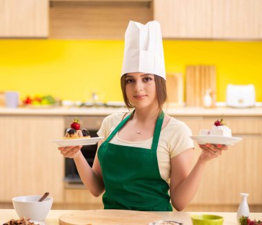 Genç aşçı mutfakta kek pişiriyor.