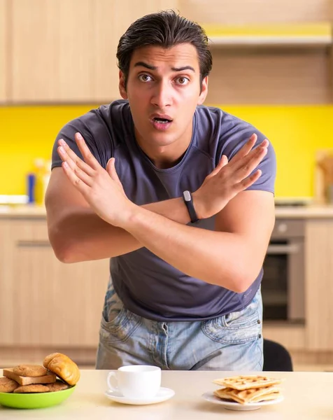 Junger Mann mit ungesundem Ernährungskonzept — Stockfoto