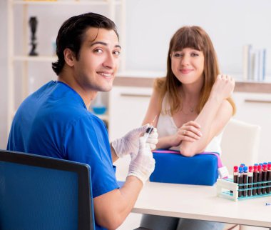 Kan testi örnekleme işlemi sırasında genç bir hasta.