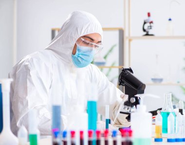 Laboratuvarda kimyasallar üzerinde çalışan genç bir kimyager.