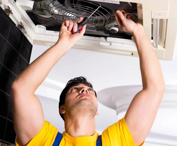 Repairman repairing ceiling air conditioning unit — Stock Photo, Image