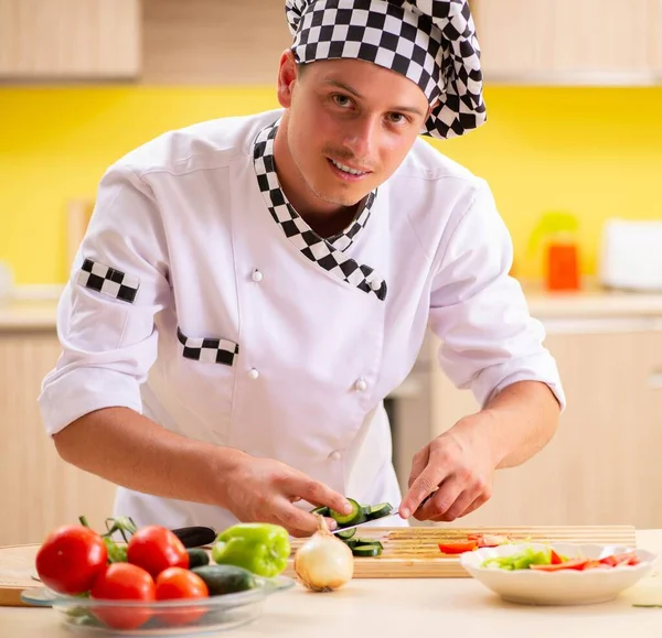 Young professional cook preparing salad at kitchen — Stock Photo, Image