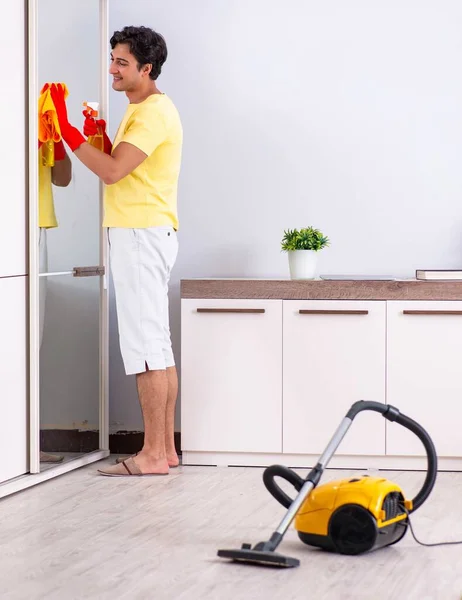 Joven hombre guapo limpieza en el dormitorio — Foto de Stock