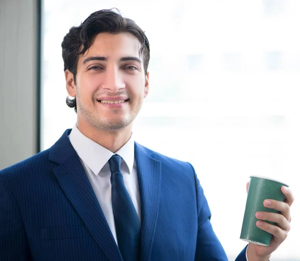 Junger gutaussehender Geschäftsmann steht am Fenster — Stockfoto