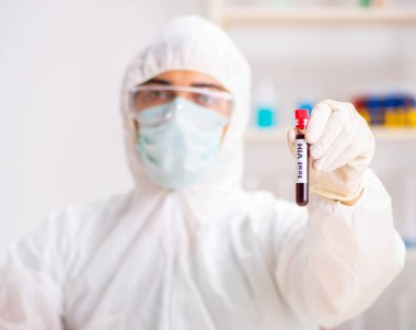 Genç yakışıklı laboratuvar asistanı hastanede kan örnekleri test ediyor.