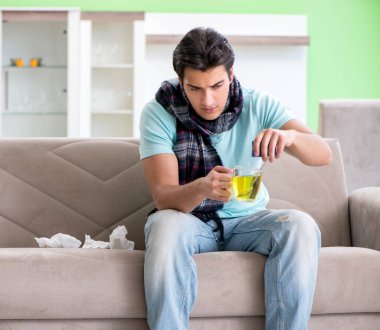 Evde hastalıktan muzdarip genç yakışıklı bir adam.