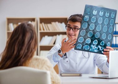 Genç doktor bilgisayardaki röntgen görüntülerine bakıyor.