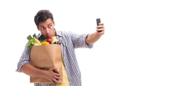 Joven con su tienda de comestibles en blanco — Foto de Stock