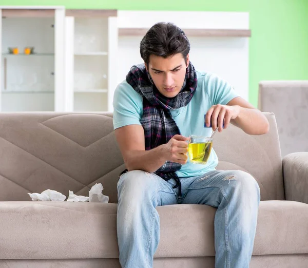 Evde hastalıktan muzdarip genç yakışıklı bir adam.