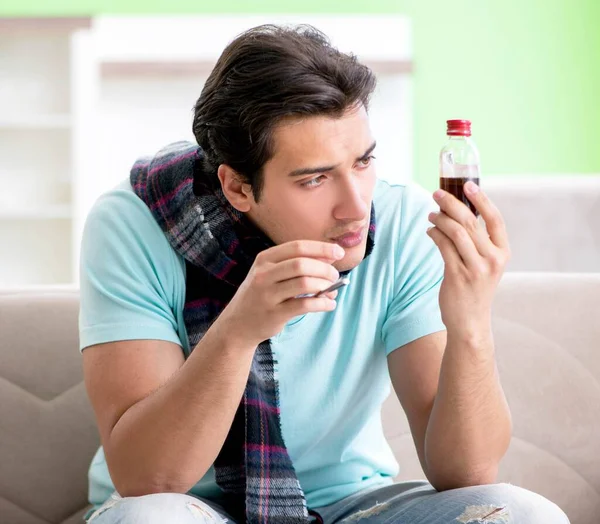 Evde hastalıktan muzdarip genç yakışıklı bir adam.