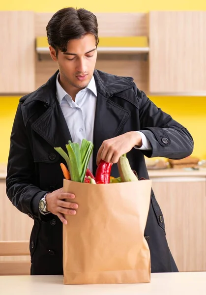 Fiatal jóképű férfi zöldségekkel a konyhában — Stock Fotó