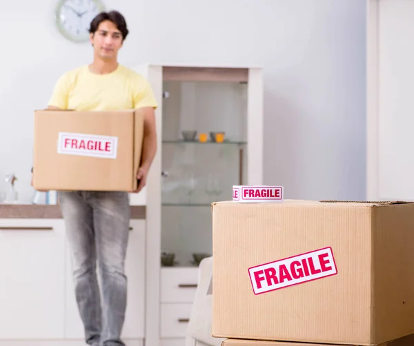 Hombre mudanza casa y reubicación con elementos frágiles — Foto de Stock