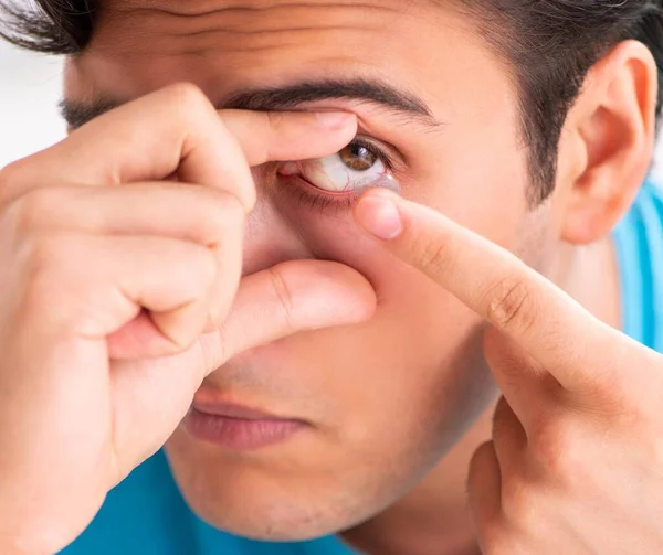 Homem tentando lentes de contato em casa — Fotografia de Stock