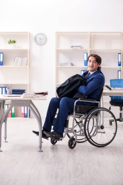 Ofiste çalışan tekerlekli sandalyede çalışan genç bir erkek.