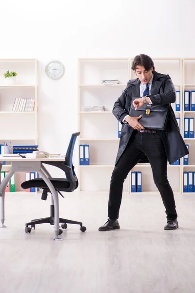 Joven empleado masculino en la oficina en concepto de gestión del tiempo —  Fotos de Stock