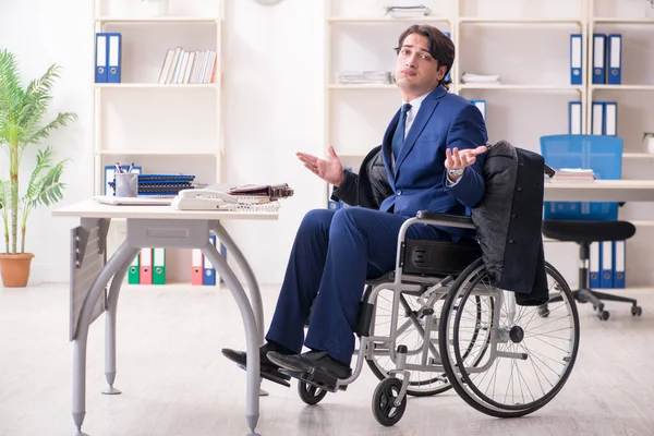 Junge männliche Angestellte im Rollstuhl bei der Arbeit im Büro — Stockfoto