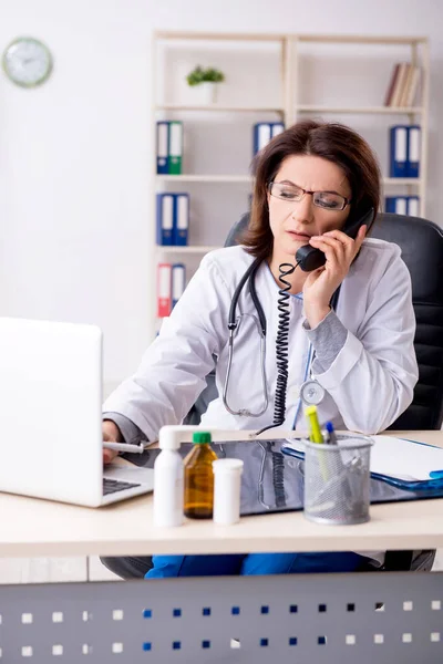 Aged female doctor working in the clinic — Stock Photo, Image