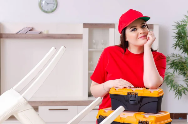 Giovane donna che ripara sedia a casa — Foto Stock