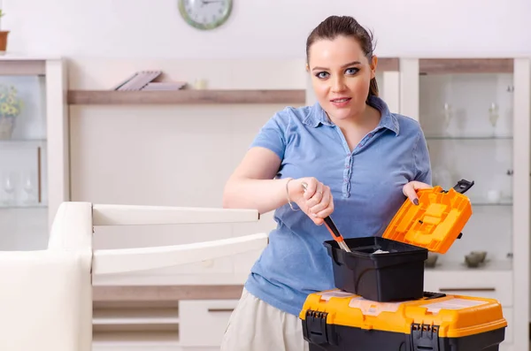 Jonge vrouw repareert stoel thuis — Stockfoto